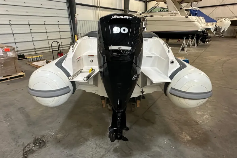 Slide: The Image of 2022 Walker Bay Venture 16 boat with Mercury 90 engine in a storage facility. - 5