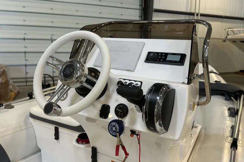 Slide: The Image of 2022 Walker Bay Venture 16 boat dashboard with steering wheel and controls. - 7