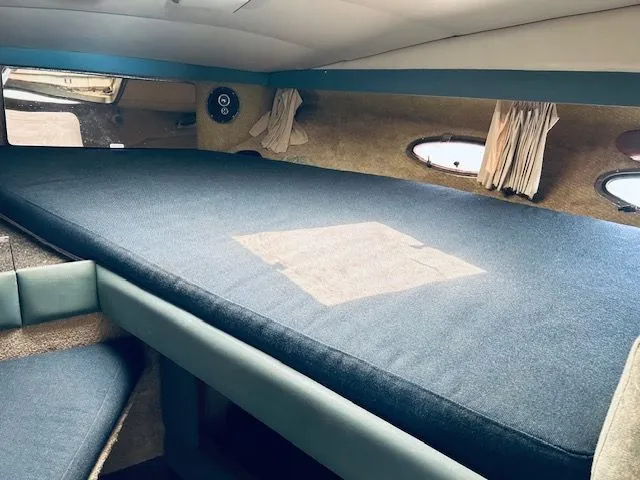 Slide: The Image of 1989 Bayliner Avanti 3255 Sunbridge cabin interior with blue upholstery and porthole windows. - 8