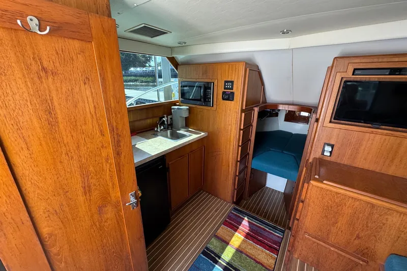 Slide: The Image of 1975 Chris Craft 30 Tournament SF interior with wood finish, kitchenette, and cozy sleeping area. - 22