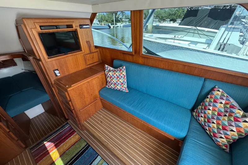Slide: The Image of 1975 Chris Craft 30 Tournament SF interior with blue seating, colorful pillows, and wood accents. - 23