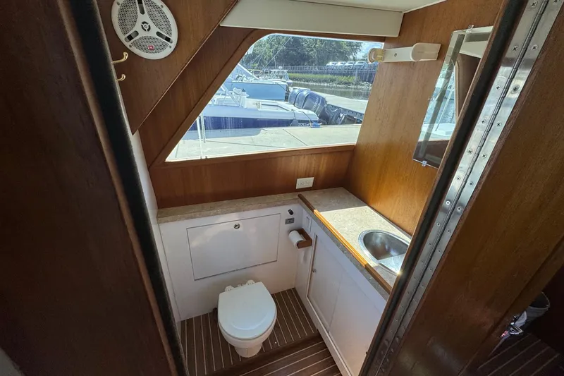 Slide: The Image of Interior of 1975 Chris Craft 30 Tournament SF boat, featuring a compact bathroom with sink and toilet. - 27