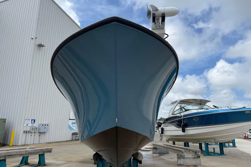 Slide: The Image of 2023 Front Runner 33 CC boat in a marina, blue hull, clear sky background. - 2