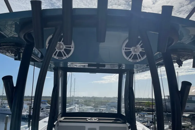 Slide: The Image of 2023 Front Runner 33 CC boat with speakers and rod holders, docked at marina. - 23