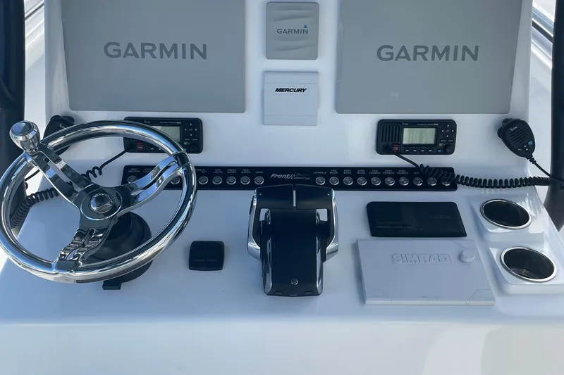 Slide: The Image of 2023 Front Runner 33 CC boat dashboard with Garmin displays and steering wheel. - 26
