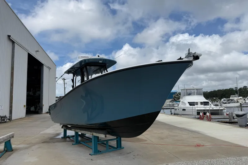 Slide: The Image of 2023 Front Runner 33 CC boat on display at a marina with cloudy sky. - 3