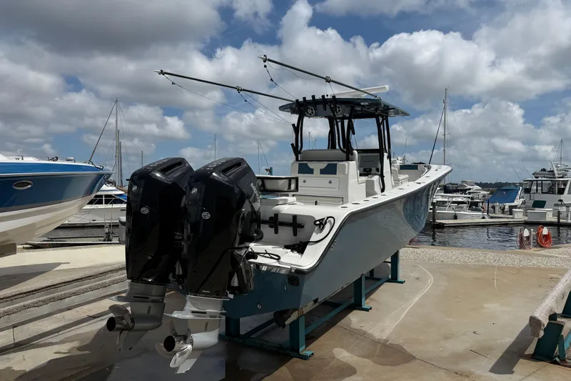 Slide: The Image of 2023 Front Runner 33 CC boat with dual engines docked at a marina. - 6