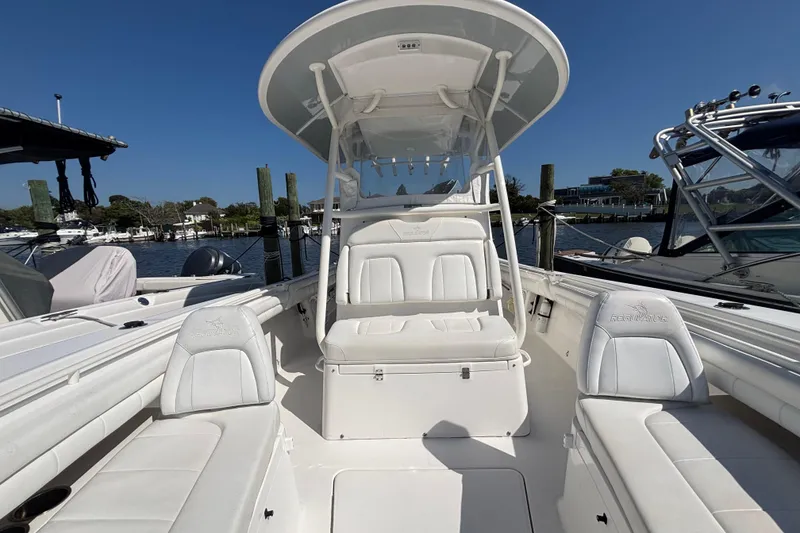 Slide: The Image of 2017 Regulator 28 boat with white seating and T-top, docked at a marina. - 11