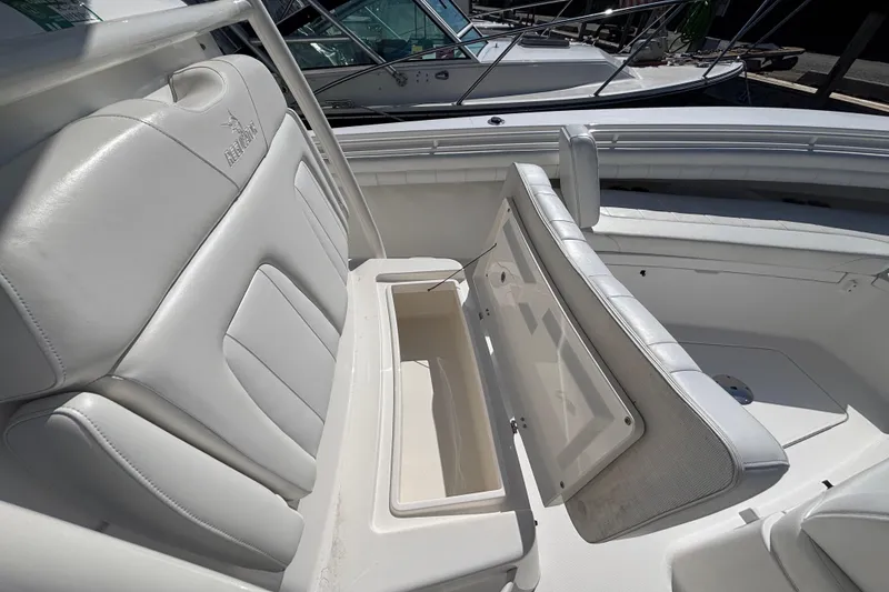 Slide: The Image of 2017 Regulator 28 boat with open storage compartment and white cushioned seating. - 12