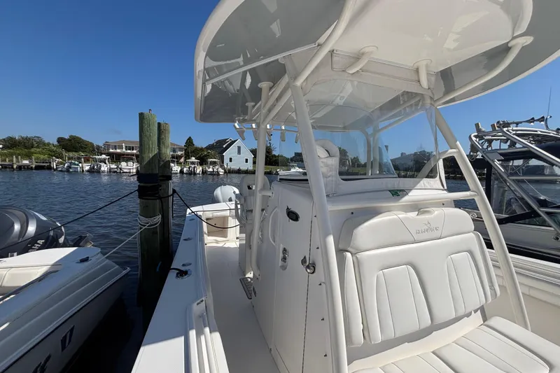 Slide: The Image of 2017 Regulator 28 boat docked, featuring sleek white design and spacious seating. - 14