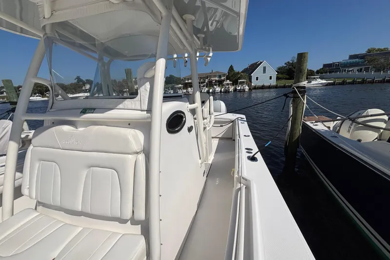 Slide: The Image of 2017 Regulator 28 boat docked by waterfront homes under clear blue sky. - 15