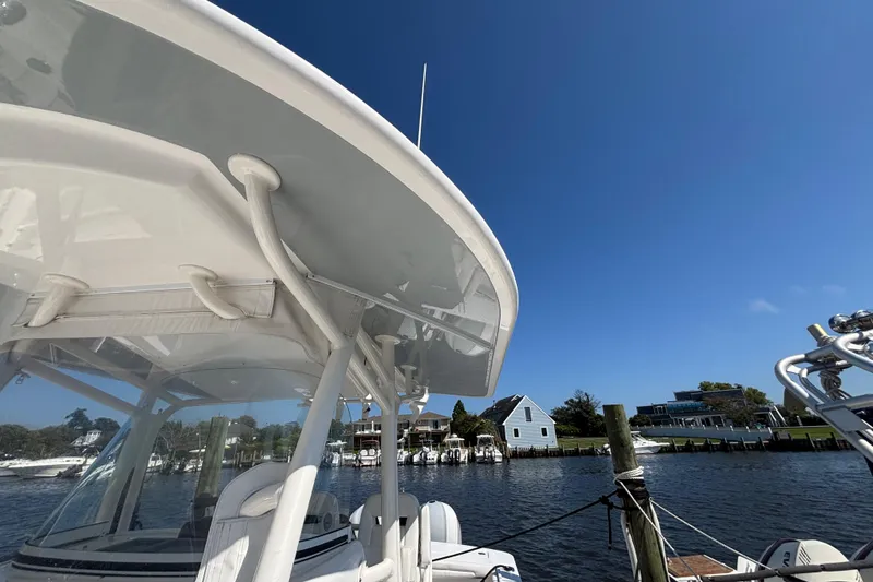 Slide: The Image of 2017 Regulator 28 boat docked by waterfront homes under clear blue sky. - 17