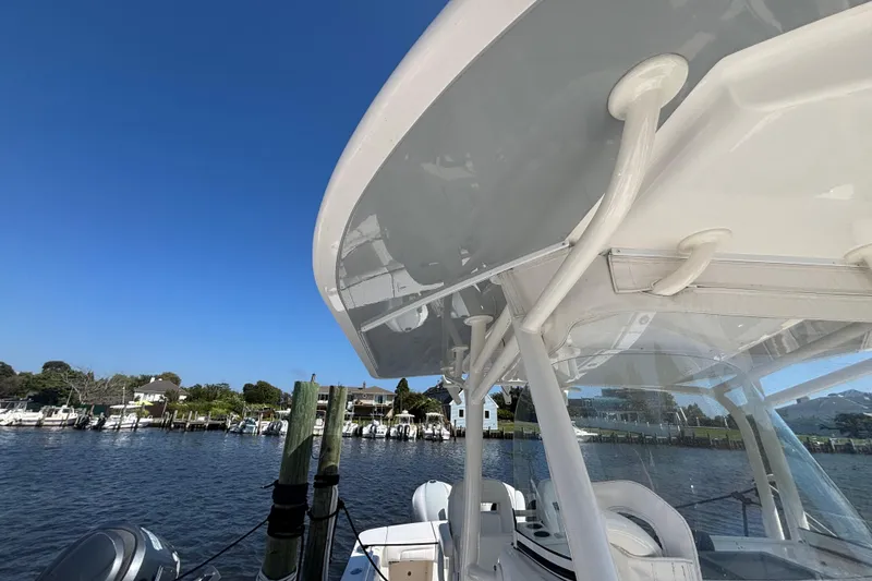 Slide: The Image of 2017 Regulator 28 boat with T-top, docked by a scenic waterfront. - 18