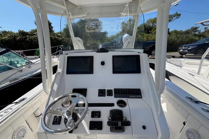 Slide: The Image of 2017 Regulator 28 boat dashboard with dual screens and steering wheel. - 20