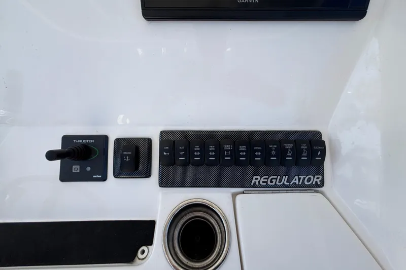 Slide: The Image of Control panel of a 2017 Regulator 28 boat with switches and thruster. - 26