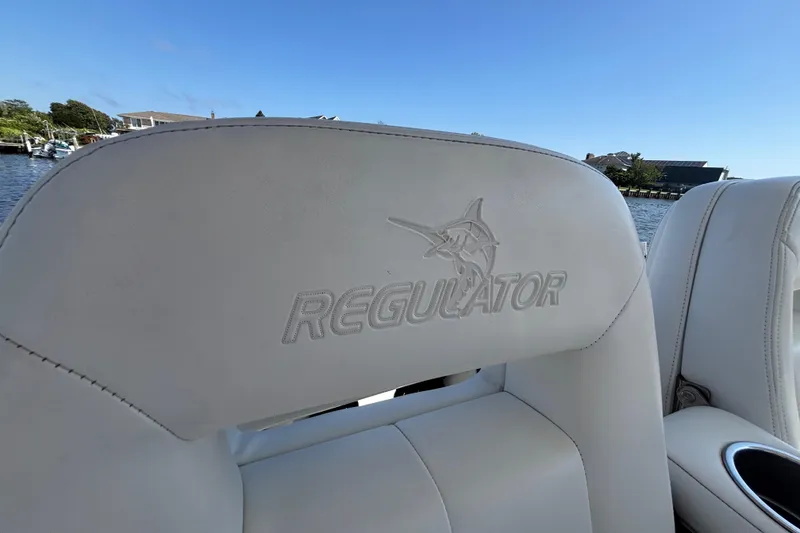 Slide: The Image of 2017 Regulator 28 boat seat with logo, overlooking a scenic waterfront. - 29