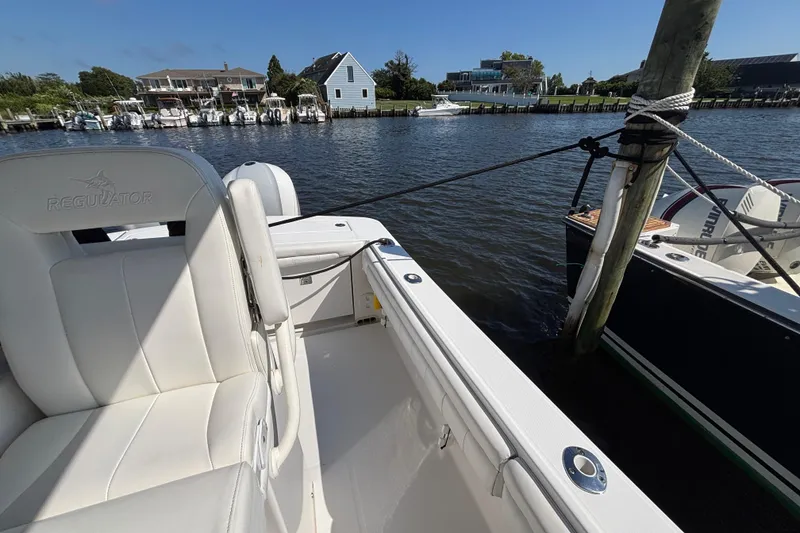 Slide: The Image of 2017 Regulator 28 boat docked in a scenic marina with waterfront homes. - 39