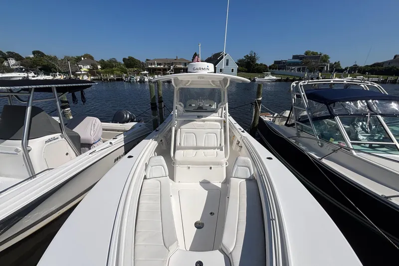 Slide: The Image of 2017 Regulator 28 boat docked at marina, surrounded by other boats, clear sky. - 4