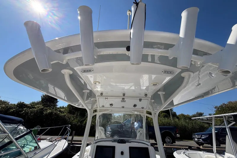 Slide: The Image of 2017 Regulator 28 boat with T-top and rod holders under clear blue sky. - 43