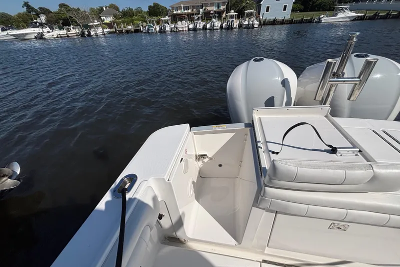 Slide: The Image of 2017 Regulator 28 boat stern view with dual engines, docked near waterfront homes. - 45