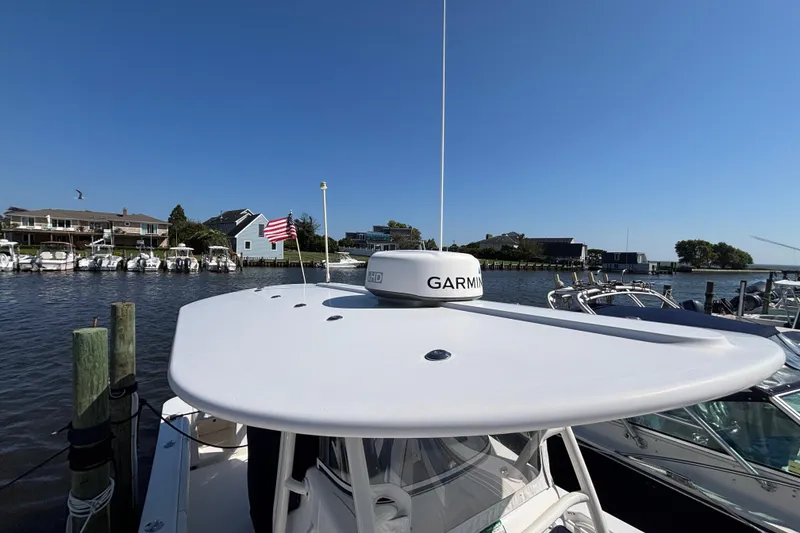 Slide: The Image of 2017 Regulator 28 boat docked, featuring Garmin radar, American flag, and waterfront view. - 51