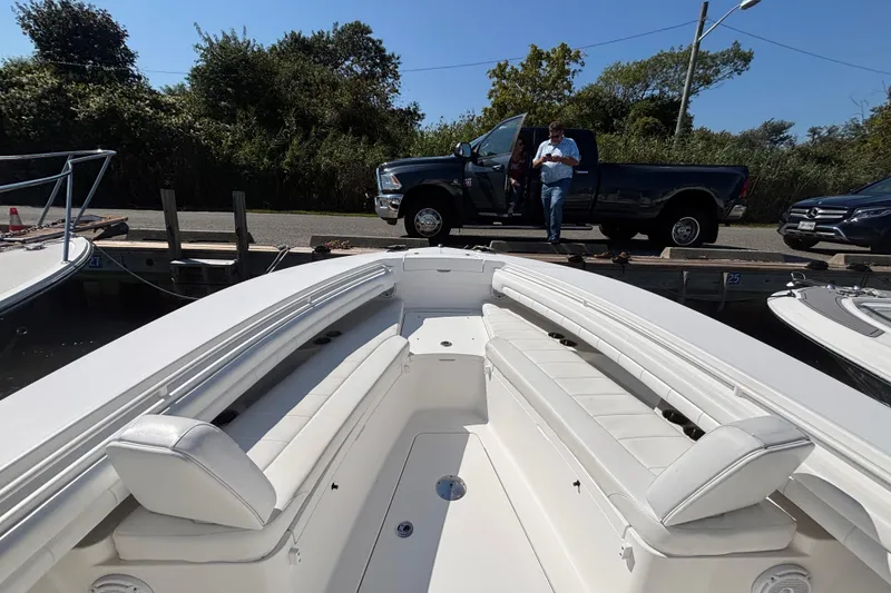 Slide: The Image of 2017 Regulator 28 boat interior with docked pickup truck in background. - 6