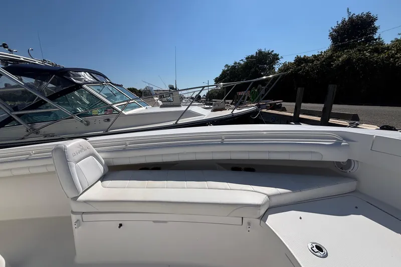 Slide: The Image of 2017 Regulator 28 boat with white seating, docked under clear blue sky. - 7