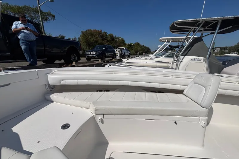 Slide: The Image of 2017 Regulator 28 boat interior with white seating, docked alongside other boats under clear blue sky. - 8