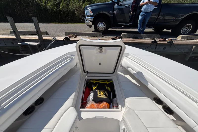 Slide: The Image of 2017 Regulator 28 boat with open storage compartment, docked near a pickup truck. - 9