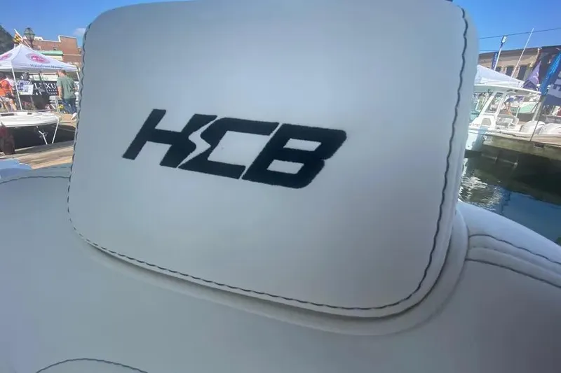 Slide: The Image of HCB 39 Speciale 2025 boat seat with logo, displayed at a marina event. - 13