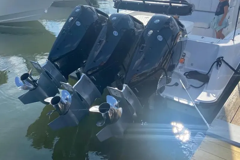 Slide: The Image of 2025 HCB 39 Speciale boat with triple outboard engines docked in water. - 3