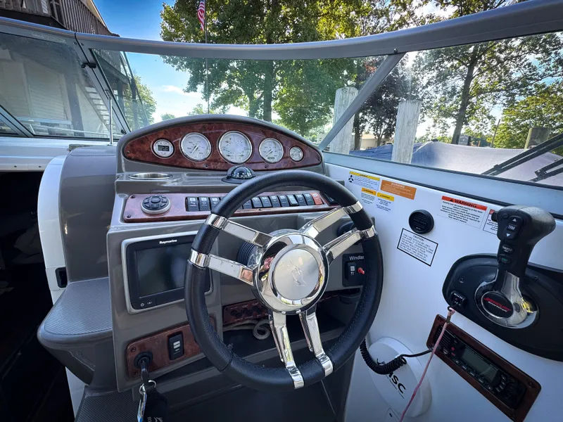 Slide: The Image of 2016 Rinker 290 Express boat dashboard with steering wheel and control panel. - 12