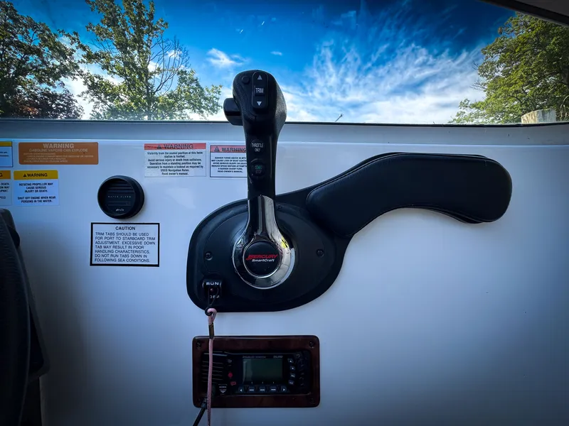 Slide: The Image of Control panel of a 2016 Rinker 290 Express boat with throttle and warning labels. - 17