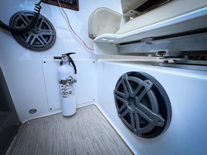 Slide: The Image of 2016 Rinker 290 Express boat interior with speakers and fire extinguisher. - 18
