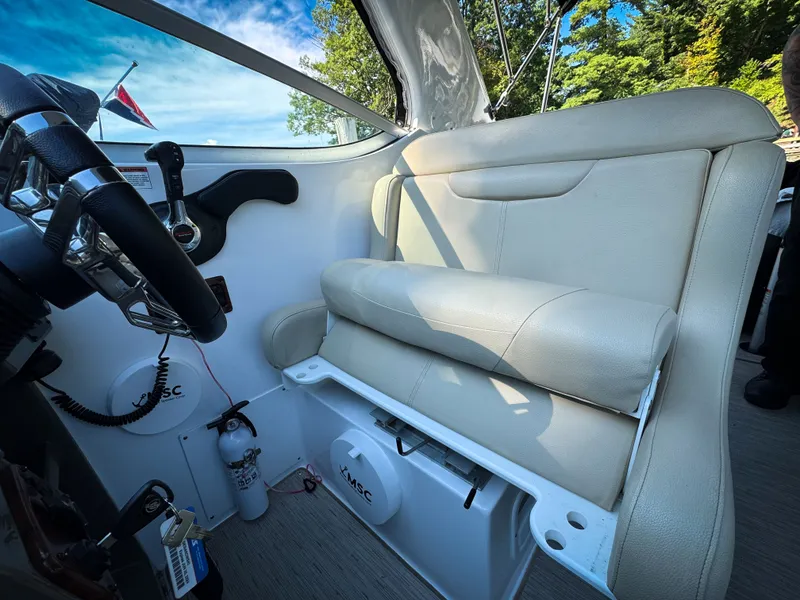 Slide: The Image of Interior of 2016 Rinker 290 Express boat with beige seating and steering wheel. - 20