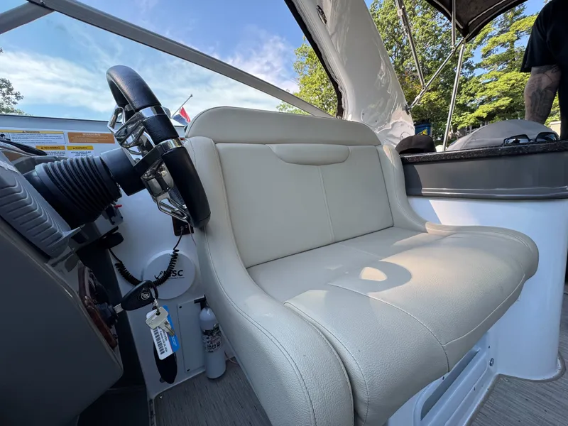 Slide: The Image of 2016 Rinker 290 Express boat interior with steering wheel and beige seating. - 21