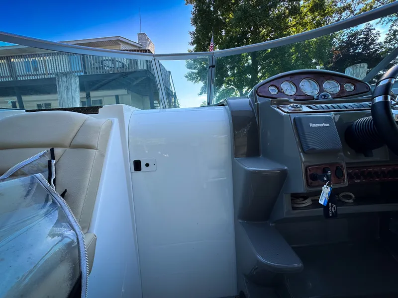 Slide: The Image of 2016 Rinker 290 Express boat cockpit with steering wheel and control panel. - 22