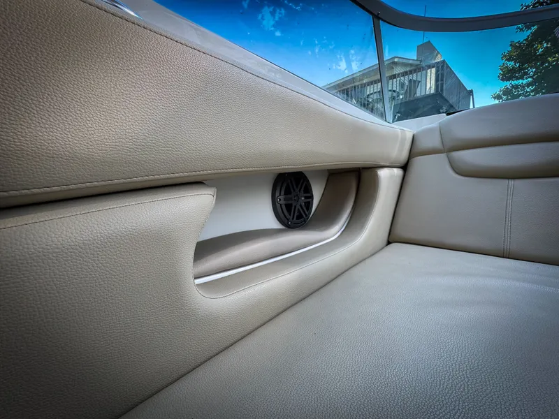 Slide: The Image of Interior of 2016 Rinker 290 Express boat with beige leather seating and speaker. - 25