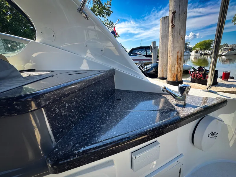 Slide: The Image of 2016 Rinker 290 Express boat with sleek countertop and faucet at marina. - 31