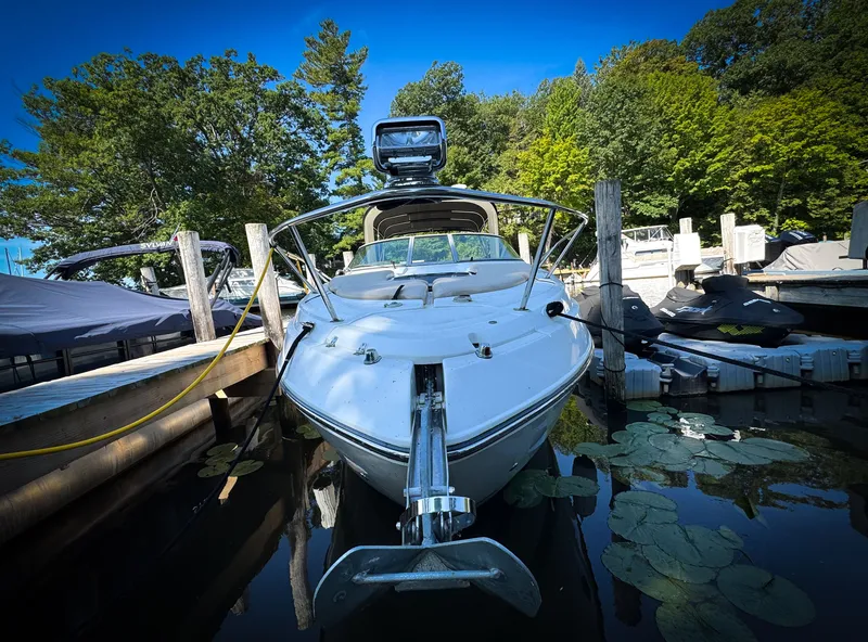 Slide: The Image of 2016 Rinker 290 Express boat docked, surrounded by lush greenery and calm water. - 6