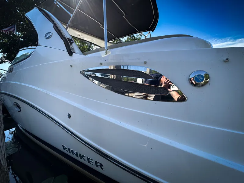 Slide: The Image of 2016 Rinker 290 Express boat side view with sleek design and chrome accents. - 8