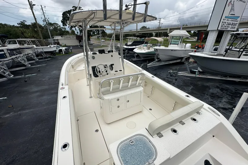 Slide: The Image of 2022 Cobia 237 Center Console boat with spacious deck and modern helm, parked outdoors. - 12