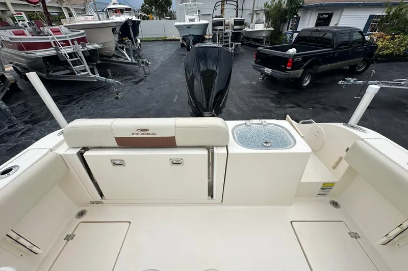 Slide: The Image of 2022 Cobia 237 Center Console boat with motor and sink, parked in a marina. - 16