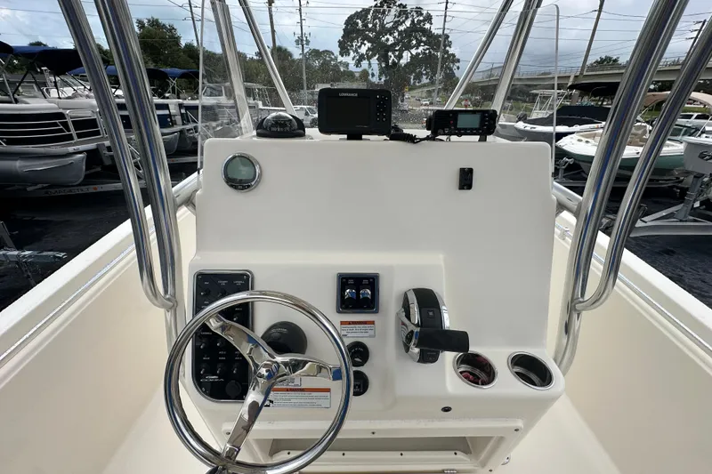 Slide: The Image of 2022 Cobia 237 Center Console boat dashboard with steering wheel and controls. - 23