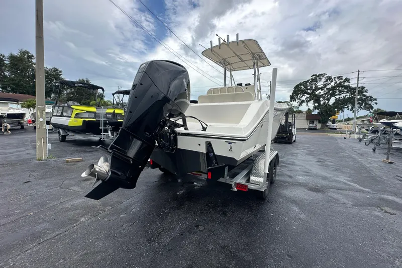 Slide: The Image of 2022 Cobia 237 Center Console boat on trailer, featuring powerful outboard motor. - 5