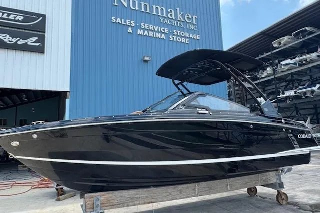 The Image of 2026 Cobalt R4 Surf boat displayed at Nunmaker Yachts, black exterior, marina background. - 1