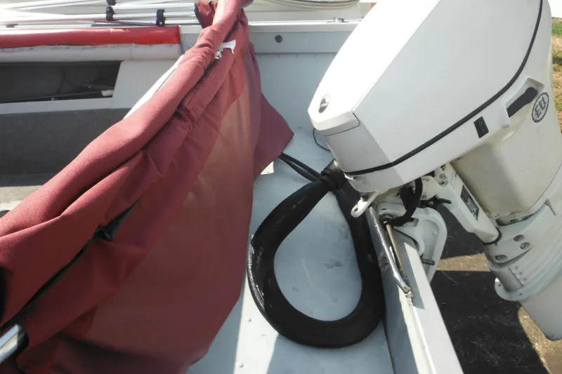 Slide: The Image of 1993 Sea Nymph SS175 Fish-n-ski boat interior with motor and maroon cover. - 6