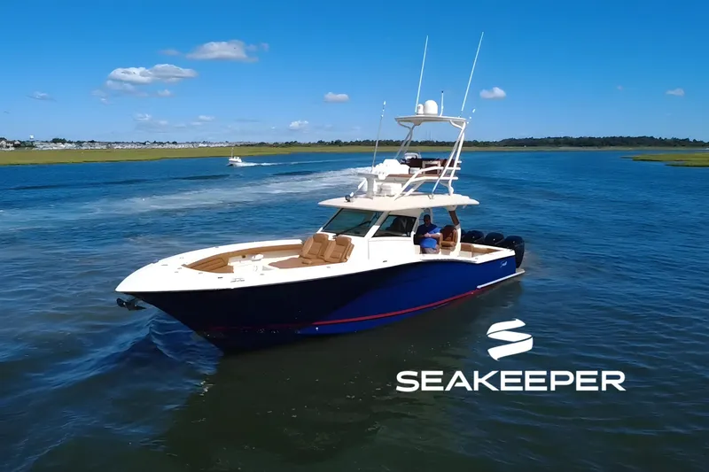 The Image of 2016 Scout 420 LXF boat cruising on open water under clear blue skies. - 0
