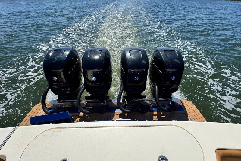 Slide: The Image of Four powerful outboard engines on a 2016 Scout 420 LXF boat cruising on water. - 11