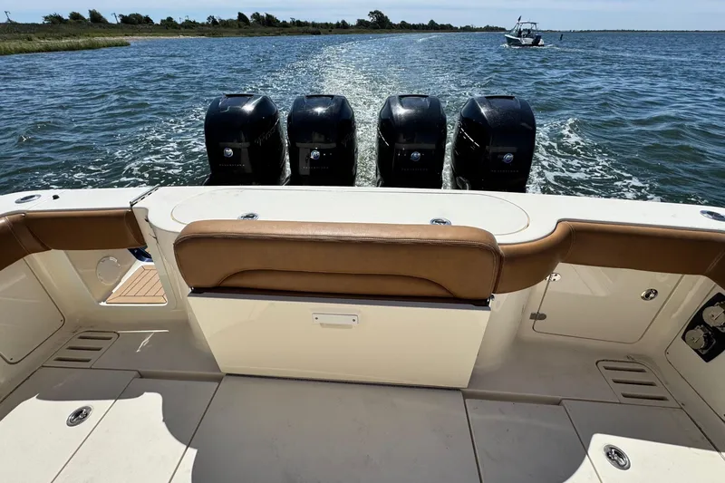 Slide: The Image of 2016 Scout 420 LXF boat with four outboard engines on open water. - 12
